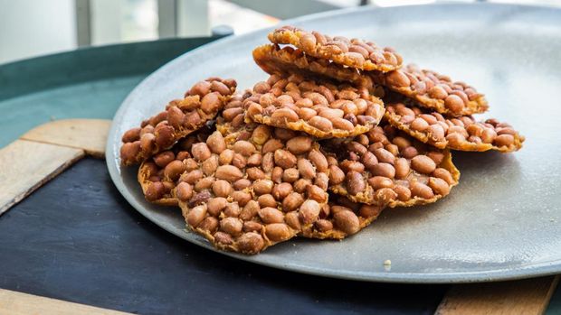 Ilustrasi ampyang gula kacang Traditional Thai Snack : Peanut crackers made from nuts and flour to fry on plate. Deep Fried Bean cookies peanut, Selective focus.