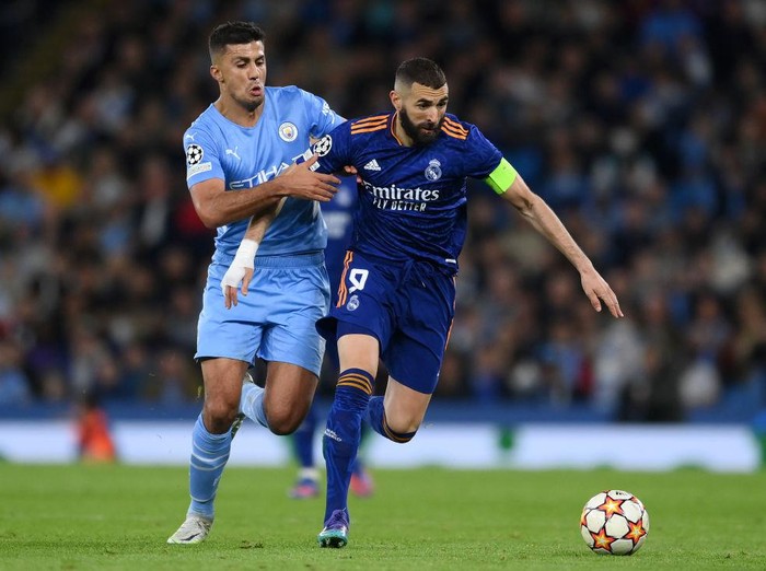 MANCHESTER, ENGLAND - APRIL 26: Karim Benzema of Real Madrid holds off Rodrigo of Manchester City during the UEFA Champions League Semi Final Leg One match between Manchester City and Real Madrid at Etihad Stadium on April 26, 2022 in Manchester, England. (Photo by David Ramos/Getty Images)