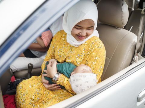 Little baby boy with her muslim mom inside car going for a trip
