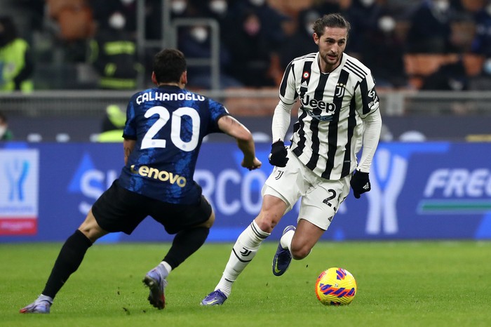 MILAN, ITALY - JANUARY 12: Adrien Rabiot of Juventus battles for possession with Hakan Calhanoglu of Inter Milan during the Italian Supercup match between Inter and Juventus at The San Siro on January 12, 2022 in Milan, Italy. (Photo by Marco Luzzani/Getty Images)
