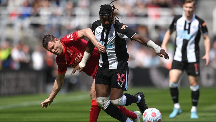 NEWCASTLE UPON TYNE, ENGLAND - APRIL 30: Allan Saint-Maximin of Newcastle United is challenged by James Milner of Liverpool during the Premier League match between Newcastle United and Liverpool at St. James Park on April 30, 2022 in Newcastle upon Tyne, England. (Photo by Stu Forster/Getty Images)