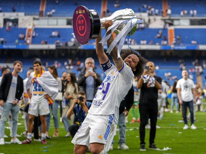 Real Madrid's Marcelo lifts the trophy to celebrate the team's La Liga title after a Spanish La Liga soccer match between Real Madrid and Espanyol at the Santiago Bernabeu stadium in Madrid, Saturday, April 30, 2022. (AP Photo/Bernat Armangue)