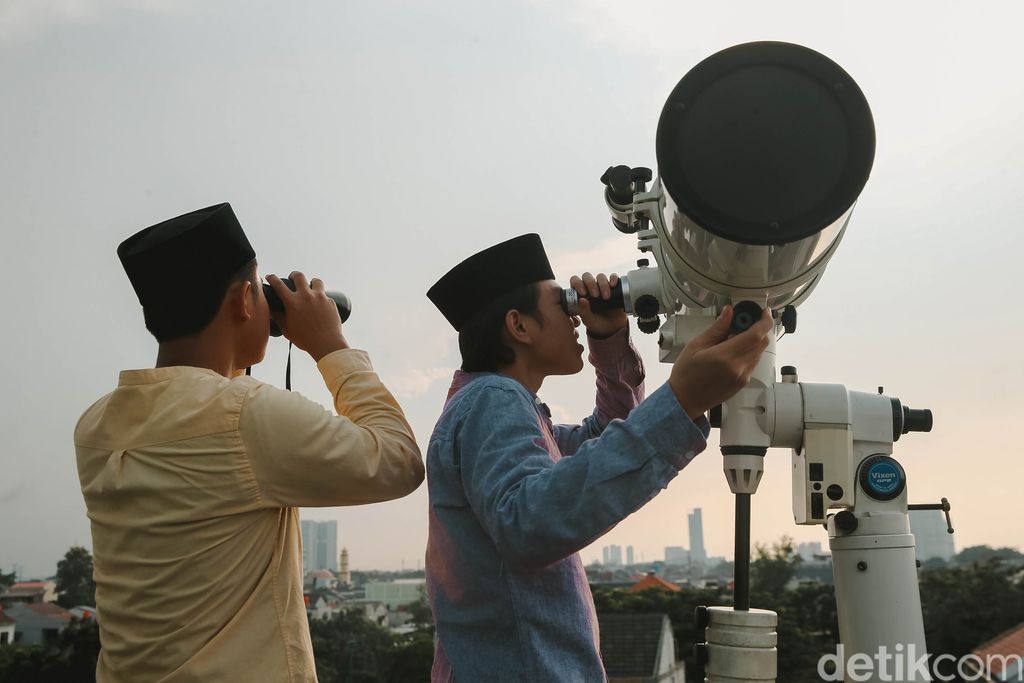 Petugas Masjid Al-Musyariin mengamati posisi hilal menggunakan teropong saat Rukyatul Hilal di Jakarta Barat, Minggu (1/5/2022). Pemantauan hilal yang dilakukan menggunakan teropong tersebut memastikan Idul Fitri 1443 H jatuh pada 2 Mei 2022.