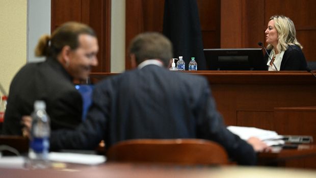 US actor Johnny Depp speaks to his attorney Ben Chew as forensic psychologist Dr. Dawn Hughes, testifies during a hearing at the Fairfax County Circuit Courthouse in Fairfax, Virginia, on May 3, 2022. US actor Johnny Depp sued his ex-wife Amber Heard for libel in Fairfax County Circuit Court after she wrote an op-ed piece in The Washington Post in 2018 referring to herself as a 