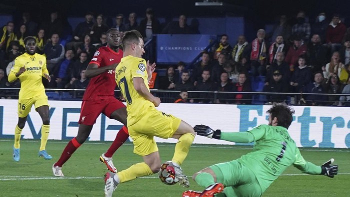 Liverpools goalkeeper Alisson, right, makes a save in front Villarreals Giovani Lo Celso during the Champions League semi final, second leg soccer match between Villarreal and Liverpool at the Ceramica stadium in Villarreal, Spain, Tuesday, May 3, 2022. (AP Photo/Alberto Saiz)