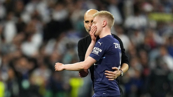 Manchester Citys head coach Pep Guardiola speaks with Manchester Citys Oleksandr Zinchenko at the end of the Champions League semi final, second leg soccer match between Real Madrid and Manchester City at the Santiago Bernabeu stadium in Madrid, Spain, Wednesday, May 4, 2022. (AP Photo/Manu Fernandez)