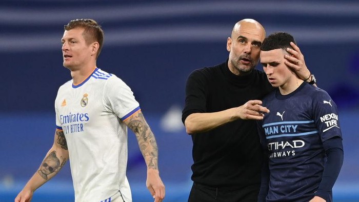 MADRID, SPAIN - MAY 04: Phil Foden of Manchester City is consoled by Pep Guardiola, Manager of Manchester City following defeat in the UEFA Champions League Semi Final Leg Two match between Real Madrid and Manchester City at Estadio Santiago Bernabeu on May 04, 2022 in Madrid, Spain. (Photo by Michael Regan/Getty Images)