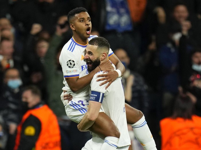 Real Madrid's Rodrygo, left, celebrates with his teammate Karim Benzema after he scored his side's first goalduring the Champions League, quarterfinal second leg soccer match between Real Madrid and Chelsea at the Santiago Bernabeu stadium in Madrid, Spain, Tuesday, April 12, 2022. (AP Photo/Manu Fernandez)