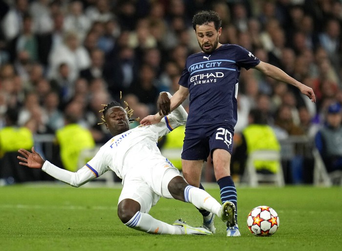 Real Madrids Eduardo Camavinga, left, duels for the ball with Manchester Citys Bernardo Silva during the Champions League semi final, second leg soccer match between Real Madrid and Manchester City at the Santiago Bernabeu stadium in Madrid, Spain, Wednesday, May 4, 2022. (AP Photo/Manu Fernandez)