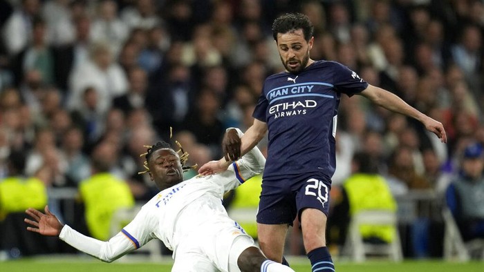 Real Madrids Eduardo Camavinga, left, duels for the ball with Manchester Citys Bernardo Silva during the Champions League semi final, second leg soccer match between Real Madrid and Manchester City at the Santiago Bernabeu stadium in Madrid, Spain, Wednesday, May 4, 2022. (AP Photo/Manu Fernandez)