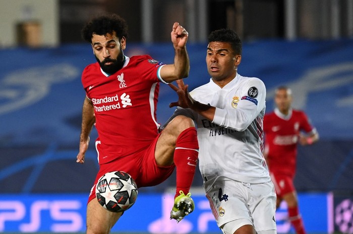 Liverpools Egyptian midfielder Mohamed Salah (L) challenges Real Madrids Brazilian midfielder Casemiro during the UEFA Champions League first leg quarter-final football match between Real Madrid and Liverpool at the Alfredo di Stefano stadium in Valdebebas in the outskirts of Madrid on April 6, 2021. (Photo by GABRIEL BOUYS / AFP)