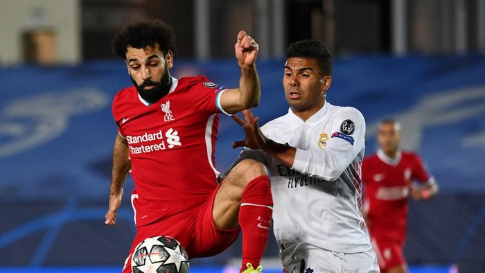 Liverpools Egyptian midfielder Mohamed Salah (L) challenges Real Madrids Brazilian midfielder Casemiro during the UEFA Champions League first leg quarter-final football match between Real Madrid and Liverpool at the Alfredo di Stefano stadium in Valdebebas in the outskirts of Madrid on April 6, 2021. (Photo by GABRIEL BOUYS / AFP)