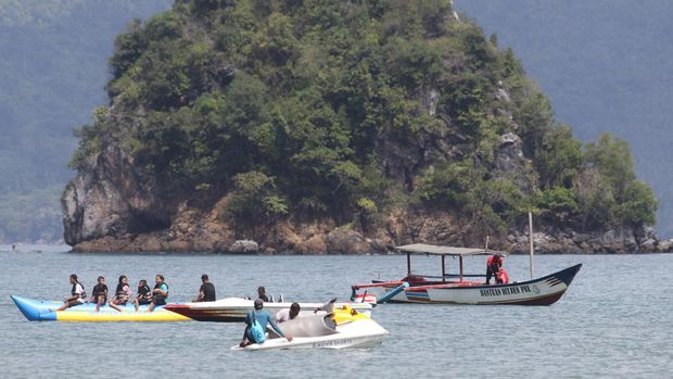 Pengunjung menaiki perahu di pantai Mutiara, Trenggalek, Jawa Timur, Minggu (8/5/2022). Wisata pantai andalan Kabupaten Trenggalek tersebut ramai pengunjung saat libur lebaran. ANTARA FOTO/Prasetia Fauzani/aww.