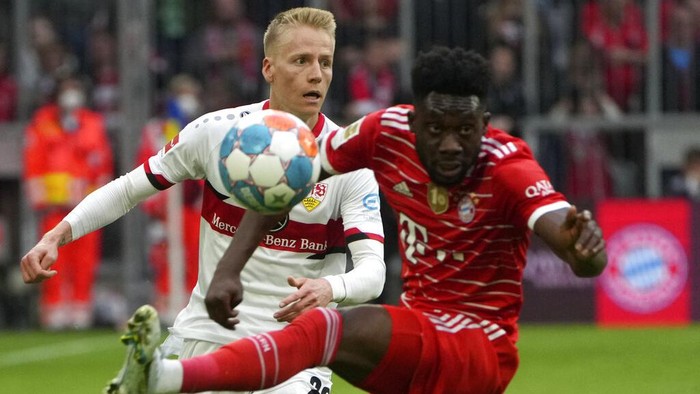 Stuttgarts Chris Fuehrich, left, duels for the ball with Bayerns Alphonso Davies during the German Bundesliga soccer match between Bayern Munich and Stuttgart, at the Allianz Arena, in Munich, Germany, Sunday, May 8, 2022. (AP Photo/Michael Probst )