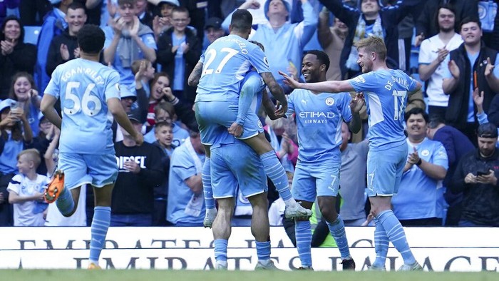 Manchester Citys Raheem Sterling, second right, celebrates with teammates after scoring his sides fifth and his second goal during the English Premier League soccer match between Manchester City and Newcastle United at Etihad stadium in Manchester, England, Sunday, May 8, 2022. (AP Photo/Jon Super)