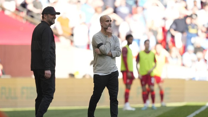Manchester Citys head coach Pep Guardiola, right, and Liverpools manager Jurgen Klopp gesture during the English FA Cup semifinal soccer match between Manchester City and Liverpool at Wembley stadium in London, Saturday, April 16, 2022. (AP Photo/Frank Augstein)
