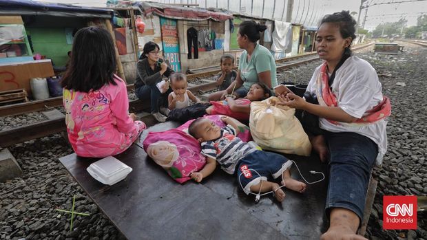 menanti masa depan kampung bayam Warga eks Kampung Bayam beraktivitas di bantaran jalur kereta api. Jakarta, Selasa. 10 Mei 2022. (CNN Indonesia/ Adhi Wicaksono)