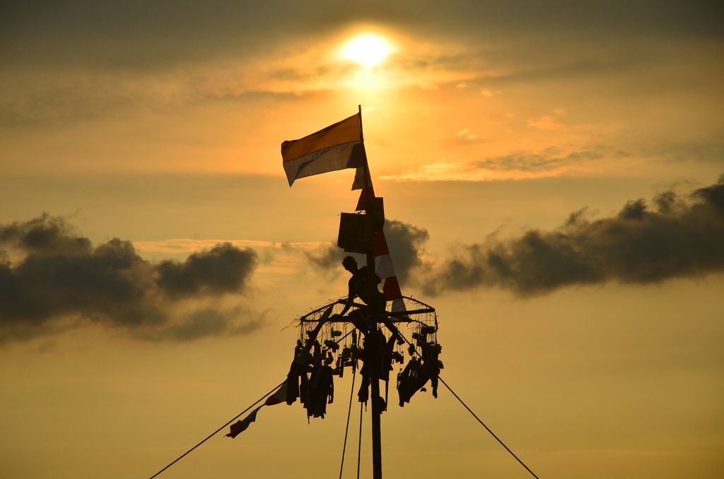Warga mengibarkan bendera merah putih saat mengikuti lomba Panjat Pinang di kawasan Pantai Kelurahan Demaan, Jepara, Jawa Tengah, Senin (9/5/2022). Panjat Pinang tersebut untuk memeriahkan tradisi Syawalan atau Lebaran ketupat serta untuk menjalin kebersamaan dan menghibur warga. ANTARA FOTO/Yusuf Nugroho/pras.
