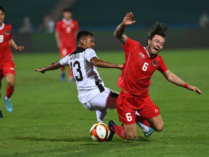 Pesepak bola Timnas Indonesia Marc Klok (kanan) terjatuh setelah dilanggar pesepakbola Timnas Timor Leste Gumario Da Silva dalam laga lanjutan Grup A Sepak Bola SEA Games 2021 Vietnam di Stadion Viet Tri, Phu Tho, Vietnam, Selasa (10/5/2022). ANTARA FOTO/Aditya Pradana Putra/rwa.