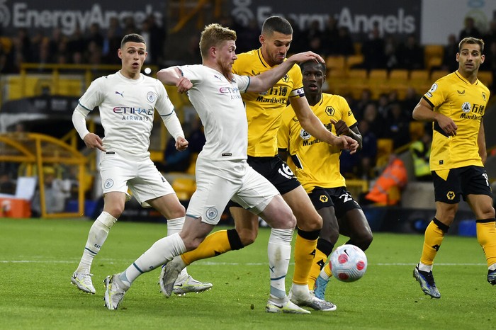 Manchester Citys Kevin De Bruyne, center, celebrates with Joao Cancelo and Raheem Sterling, right, after scoring his fourth goal during the English Premier League soccer match between Wolverhampton Wanderers and Manchester City at Molineux stadium in Wolverhampton, England, Wednesday, May 11, 2022. (AP Photo/Rui Vieira)