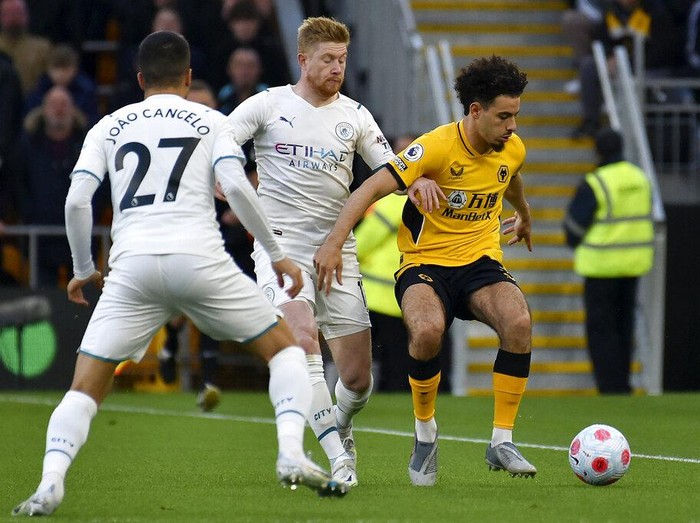 Manchester City's Kevin De Bruyne, center, celebrates with Joao Cancelo and Raheem Sterling, right, after scoring his fourth goal during the English Premier League soccer match between Wolverhampton Wanderers and Manchester City at Molineux stadium in Wolverhampton, England, Wednesday, May 11, 2022. (AP Photo/Rui Vieira)
