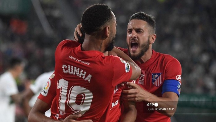 Atletico Madrids Brazilian forward Matheus Cunha (L) celebrates with teammates after scoring a goal during the Spanish league football match between Elche CF and Club Atletico de Madrid at the Martinez Valero stadium in Elche on May 11, 2022. (Photo by JOSE JORDAN / AFP)
