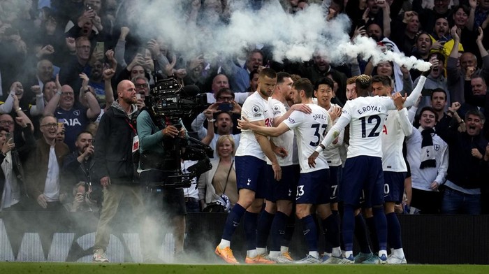 Tottenhams Emerson Royal holds up a flare as celebrates with his teammates a goal from they teammate Harry Kane after scoring with penalty against Arsenal during the English Premier League soccer match between Tottenham Hotspur and Arsenal at Tottenham Hotspur stadium in London, England, Thursday, May 12, 2022. (AP Photo/Matt Dunham)