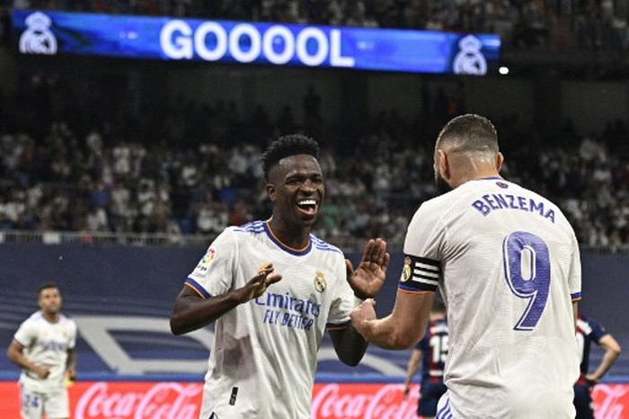 Real Madrids Brazilian forward Vinicius Junior (L) celebrates with Real Madrids French forward Karim Benzema after scoring his teams fifth goal during the Spanish league football match between Real Madrid CF and Levante UD at the Santiago Bernabeu stadium in Madrid on May 12, 2022. (Photo by JAVIER SORIANO / AFP)