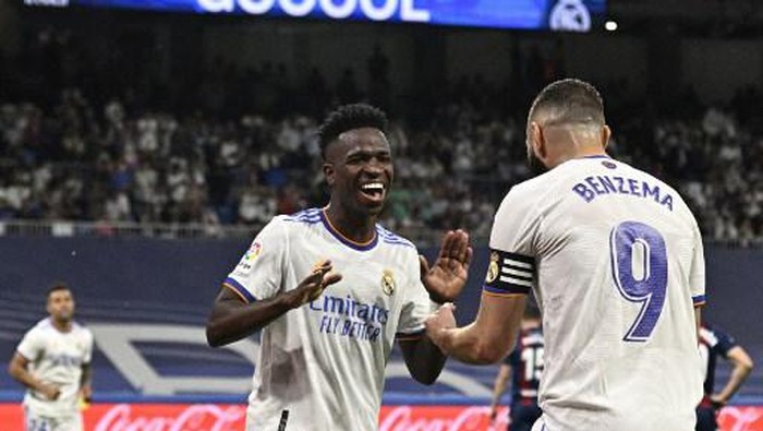 Real Madrids Brazilian forward Vinicius Junior (L) celebrates with Real Madrids French forward Karim Benzema after scoring his teams fifth goal during the Spanish league football match between Real Madrid CF and Levante UD at the Santiago Bernabeu stadium in Madrid on May 12, 2022. (Photo by JAVIER SORIANO / AFP)
