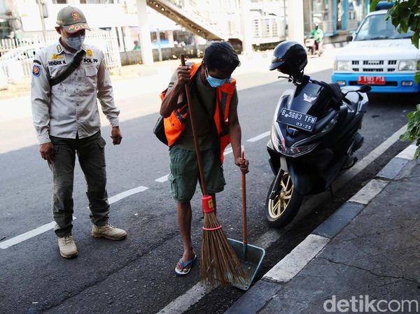Ngeyel Sih! Warga Tak Bermasker Dihukum Nyapu Jalan