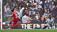 Kendati menendang penalti sambil melet, Tsimikas mampu mengecoh kiper Edouard Mendy. (Foto: AFP via Getty Images/BEN STANSALL)