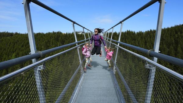 Wisatawan Beraksi di Jembatan Gantung Terpanjang Dunia