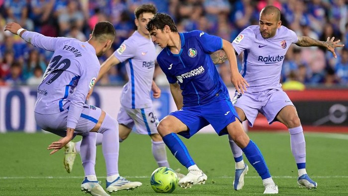 Getafes Spanish midfielder Gonzalo Villar (C) fights for the ball with Barcelonas Spanish forward Ferran Torres (L) and Barcelonas Brazilian defender Dani Alves (R) during the Spanish league football match between Getafe CF and FC Barcelona at the Col. Alfonso Perez stadium in Getafe on May 15, 2022. (Photo by JAVIER SORIANO / AFP) (Photo by JAVIER SORIANO/AFP via Getty Images)