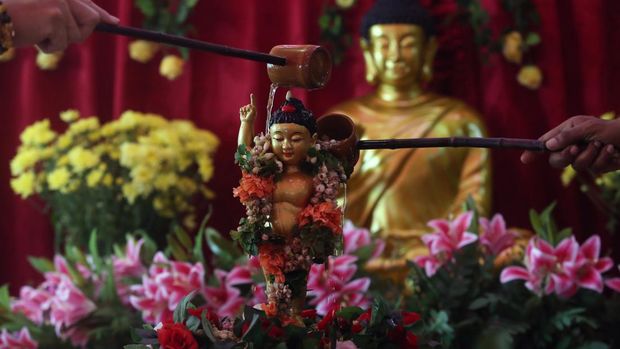 Umat Budha memandikan patung Budha kecil usai mengikuti prosesi detik-detik peringatan Trisuci Waisak 2566 BE tahun 2022 di Wihara Avalokitesvara Pondok Cabe, Tangerang Selatan, Banten, Senin (16/5/2022). ANTARA FOTO/Muhammad Iqbal/rwa.