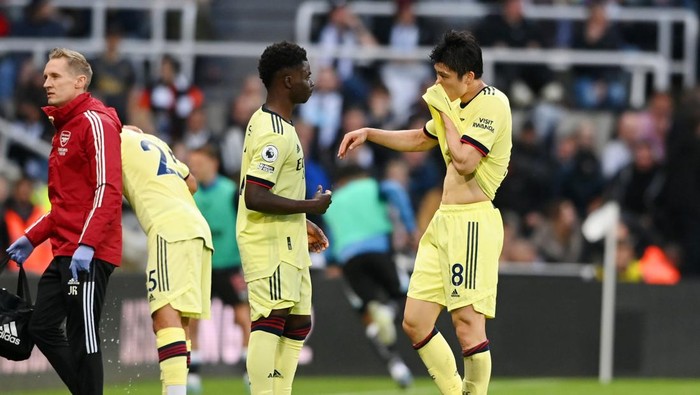 NEWCASTLE UPON TYNE, ENGLAND - MAY 16: Takehiro Tomiyasu of Arsenal (R) interacts with teammate Bukayo Saka as he is substituted off following an injury during the Premier League match between Newcastle United and Arsenal at St. James Park on May 16, 2022 in Newcastle upon Tyne, England. (Photo by Stu Forster/Getty Images)