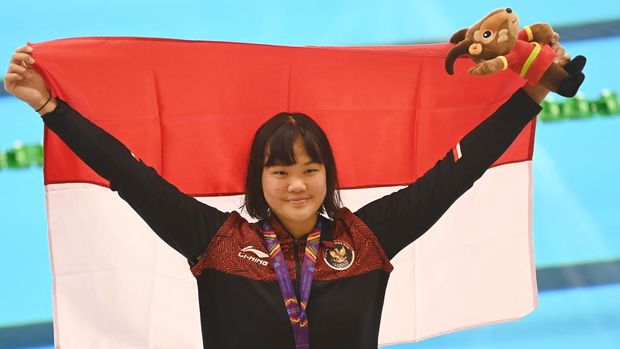 Perenang Indonesia Flairene Candrea Wonomiharjo membentangkan bendera Merah Putih usai upacara pengalungan medali nomor renang 100 meter gaya punggung putri SEA Games 2021 Vietnam di Aquatic Sport Palace, Hanoi, Vietnam, Selasa (17/5/2022). Flairene meraih medali emas setelah finis pertama dengan catatan waktu 1 menit 3,36 detik. ANTARA FOTO/Aditya Pradana Putra/rwa.
