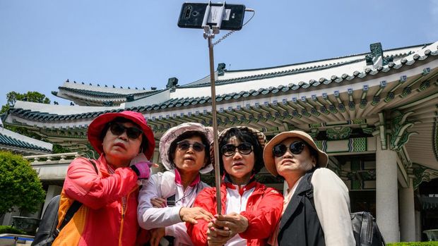 Visitors take selfie photos in the Blue House compound, a day after it was opened to the public following a campaign promise by President Yoon Suk-yeol, in Seoul on May 11, 2022. (Photo by ANTHONY WALLACE / AFP)