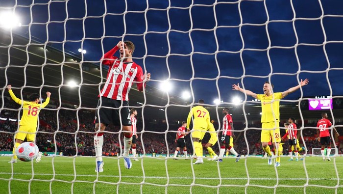 SOUTHAMPTON, ENGLAND - MAY 17: Lyanco of Southampton reacts as Takumi Minamino and Diogo Jota celebrate their sides second goal scored by Joel Matip of Liverpool (not pictured) during the Premier League match between Southampton and Liverpool at St Marys Stadium on May 17, 2022 in Southampton, England. (Photo by Clive Rose/Getty Images)