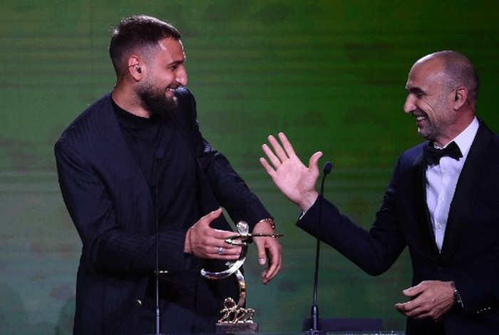 Paris Saint-Germains Italian goalkeeper Gianluigi Donnarumma (L) receives the Best Ligue 1 goalkeaper award from former goalkeaper Jerome Alonso during the TV show on May 15, 2022 in Paris, as part of the 30th edition of the UNFP (French National Professional Football players Union) trophy ceremony. (Photo by FRANCK FIFE / AFP)