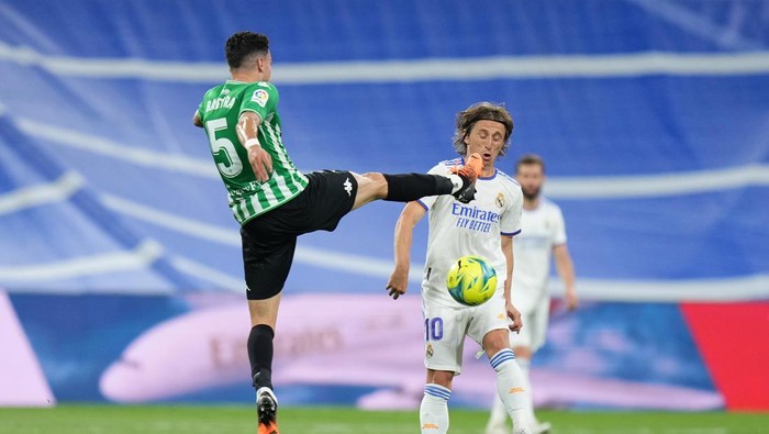 MADRID, SPAIN - MAY 20: Luka Modric of Real Madrid is challenged by Marc Bartra of Real Betis during the LaLiga Santander match between Real Madrid CF and Real Betis at Estadio Santiago Bernabeu on May 20, 2022 in Madrid, Spain. (Photo by Angel Martinez/Getty Images)