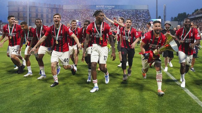AC Milans Alessio Romagnoli players holds up the trophy as he celebrates with teammates after winning the Italian Serie A title at the end of a match against Sassuolo, at the Citta del Tricolore stadium, in Reggio Emilia, Italy, Sunday, May 22, 2022. (AP Photo/Antonio Calanni)