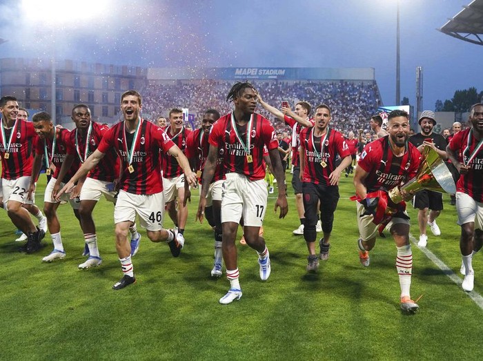 AC Milan's Alessio Romagnoli players holds up the trophy as he celebrates with teammates after winning the Italian Serie A title at the end of a match against Sassuolo, at the Citta del Tricolore stadium, in Reggio Emilia, Italy, Sunday, May 22, 2022. (AP Photo/Antonio Calanni)