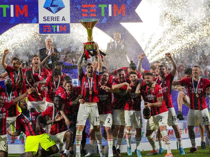 AC Milan's Alessio Romagnoli players holds up the trophy as he celebrates with teammates after winning the Italian Serie A title at the end of a match against Sassuolo, at the Citta del Tricolore stadium, in Reggio Emilia, Italy, Sunday, May 22, 2022. (AP Photo/Antonio Calanni)