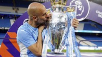 Manajer Manchester City Pep Guardiola mencium trofi Liga Inggris setelah timnya menjuarai Liga Inggris menyusul kemenangan 3-2 atas Aston Villa di The Etihad Stadium, Manchester, Inggris, Minggu (22/5/2022) waktu setempat. (Martin Rickett/PA via AP).