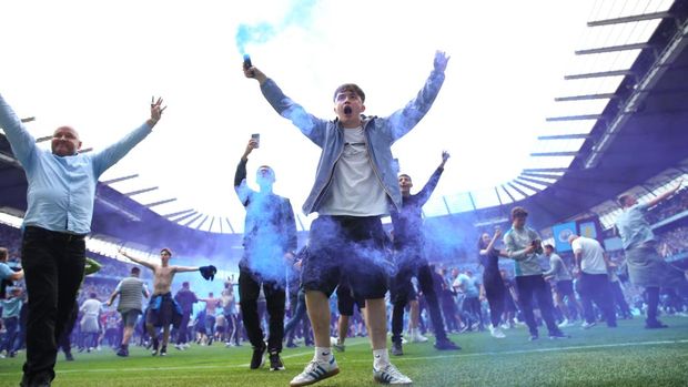 MANCHESTER, ENGLAND - MAY 22: Manchester City fans celebrate winning the Premier League title on the pitch at full time after the Premier League match between Manchester City and Aston Villa at Etihad Stadium on May 22, 2022 in Manchester, United Kingdom. (Photo by Robbie Jay Barratt - AMA/Getty Images)