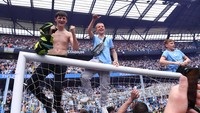 Sejumlah penggemar Manchester City merayakan kemenangan Manchester City yang meraih gelar juara Liga Inggris 2021/2022 usai mengalahkan Aston Villa 3-2 di Etihad Stadium, Minggu (22/5/2022) waktu setempat. (Photo by Stu Forster/Getty Images).
