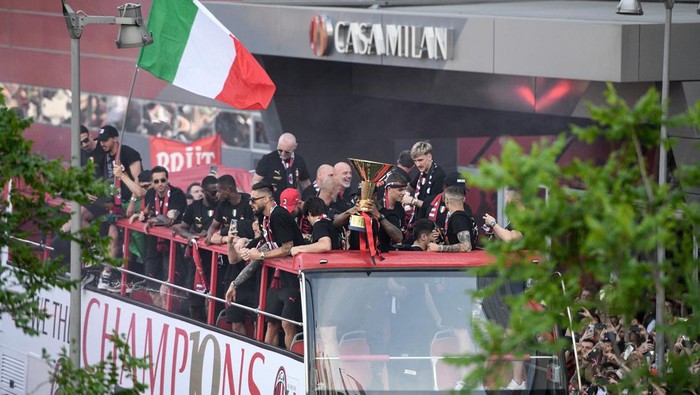 AC Milan players parade with the Scudetto Trophy on a double decker bus in front of the clubs headquarters Casa Milan in Milan, on May 23, 2022 one day after AC Milan won the Italian Serie A football match between Sassuolo and AC Milan. (Photo by Piero CRUCIATTI / AFP) (Photo by PIERO CRUCIATTI/AFP via Getty Images)