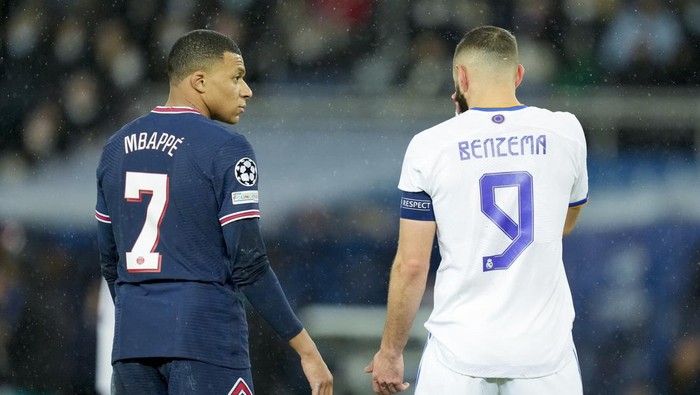 PARIS, FRANCE - FEBRUARY 15: Kylian Mbappe of Paris Saint-Germain speaks with Karim Benzema of Real Madrid CF during the UEFA Champions League Round Of Sixteen Leg One match between Paris Saint-Germain and Real Madrid at Parc des Princes on February 15, 2022 in Paris, France. (Photo by Alex Gottschalk/DeFodi Images via Getty Images)