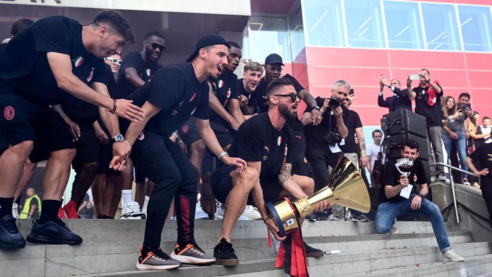 Olivier Giroud Olivier Giroud of AC Milan holds the Scudetto Trophy next to other AC Milan players celebrating at the club's headquarters Casa Milan in Milan, on May 23, 2022 one day after AC Milan won the Italian Serie A football match between Sassuolo and AC Milan. (Photo by Piero CRUCIATTI / AFP) (Photo by PIERO CRUCIATTI/AFP via Getty Images)