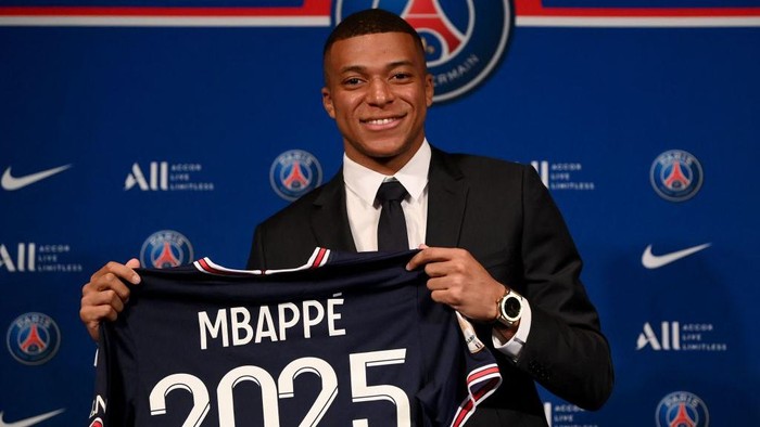 Paris Saint-Germains French forward Kylian Mbappe poses with a jersey at the end of a press conference at the Parc des Princes stadium in Paris on May 23, 2022, two days after the club won the Ligue 1 title for a record-equalling tenth time and its superstar striker Mbappe chose to sign a new contract until 2025 at PSG rather than join Real Madrid. (Photo by FRANCK FIFE / AFP) (Photo by FRANCK FIFE/AFP via Getty Images)